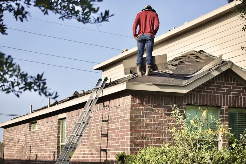 Professional roofer working on a residential roof in Sheds